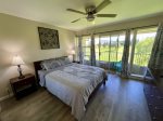 Primary bedroom with queen bed and private lanai facing the golf course.